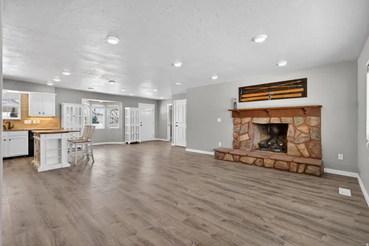 Unfurnished living room featuring a fireplace, a textured ceiling, light wood-style floors, and recessed lighting