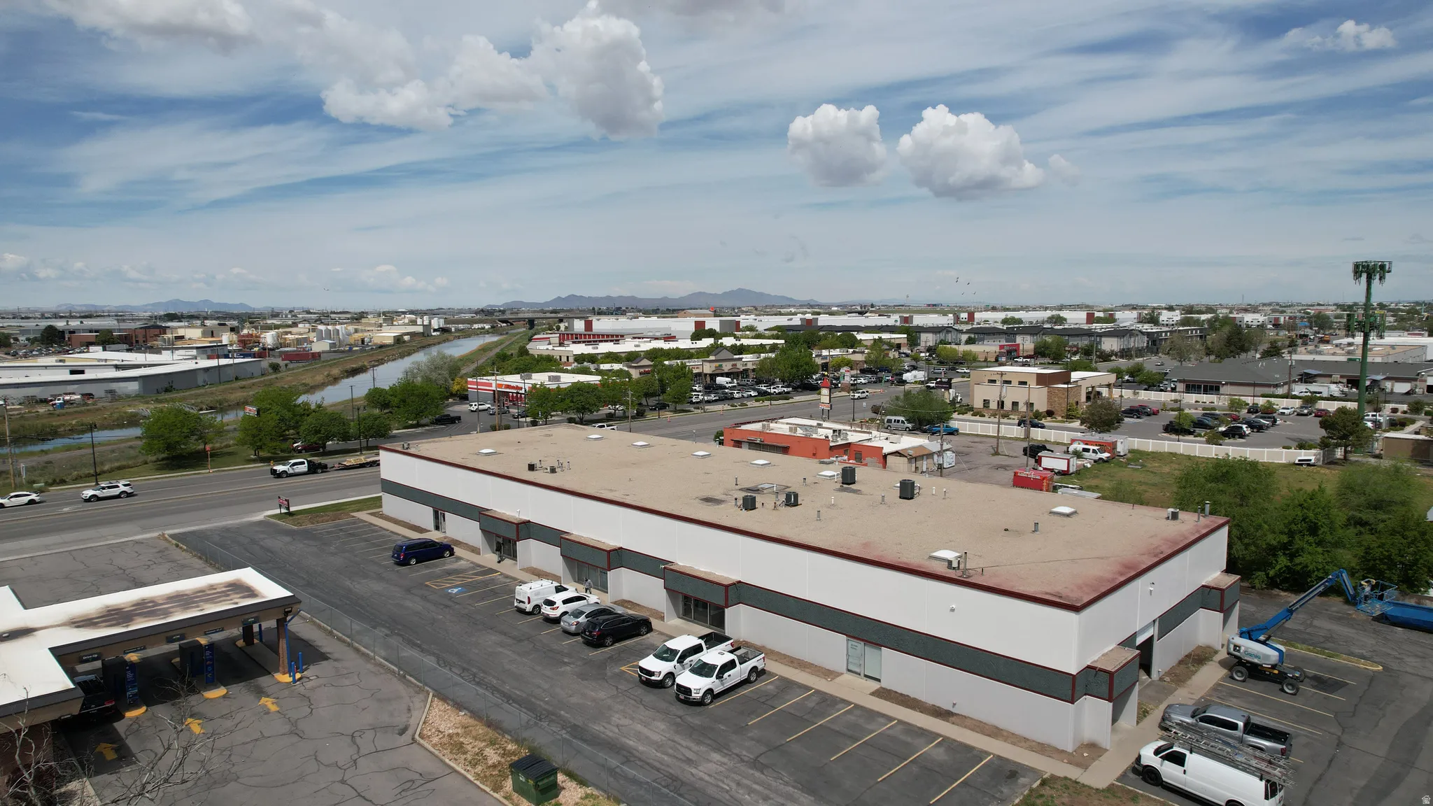 Industrial building featuring a white and gray exterior, flat roof, and multiple parking spaces