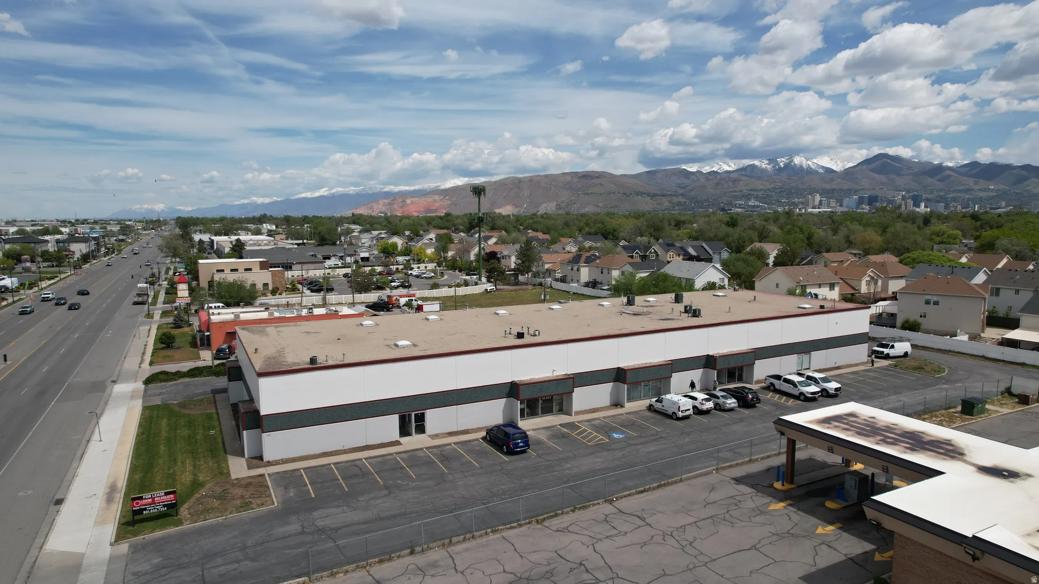 Commercial building featuring a large parking area, multiple entryways, and clear visibility from a main thoroughfare