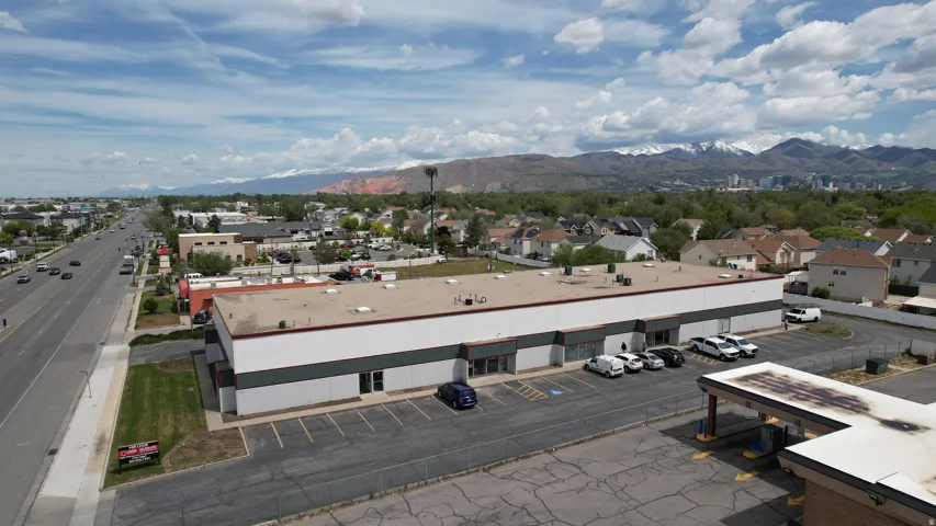 Commercial building featuring a large parking area, multiple entryways, and clear visibility from a main thoroughfare