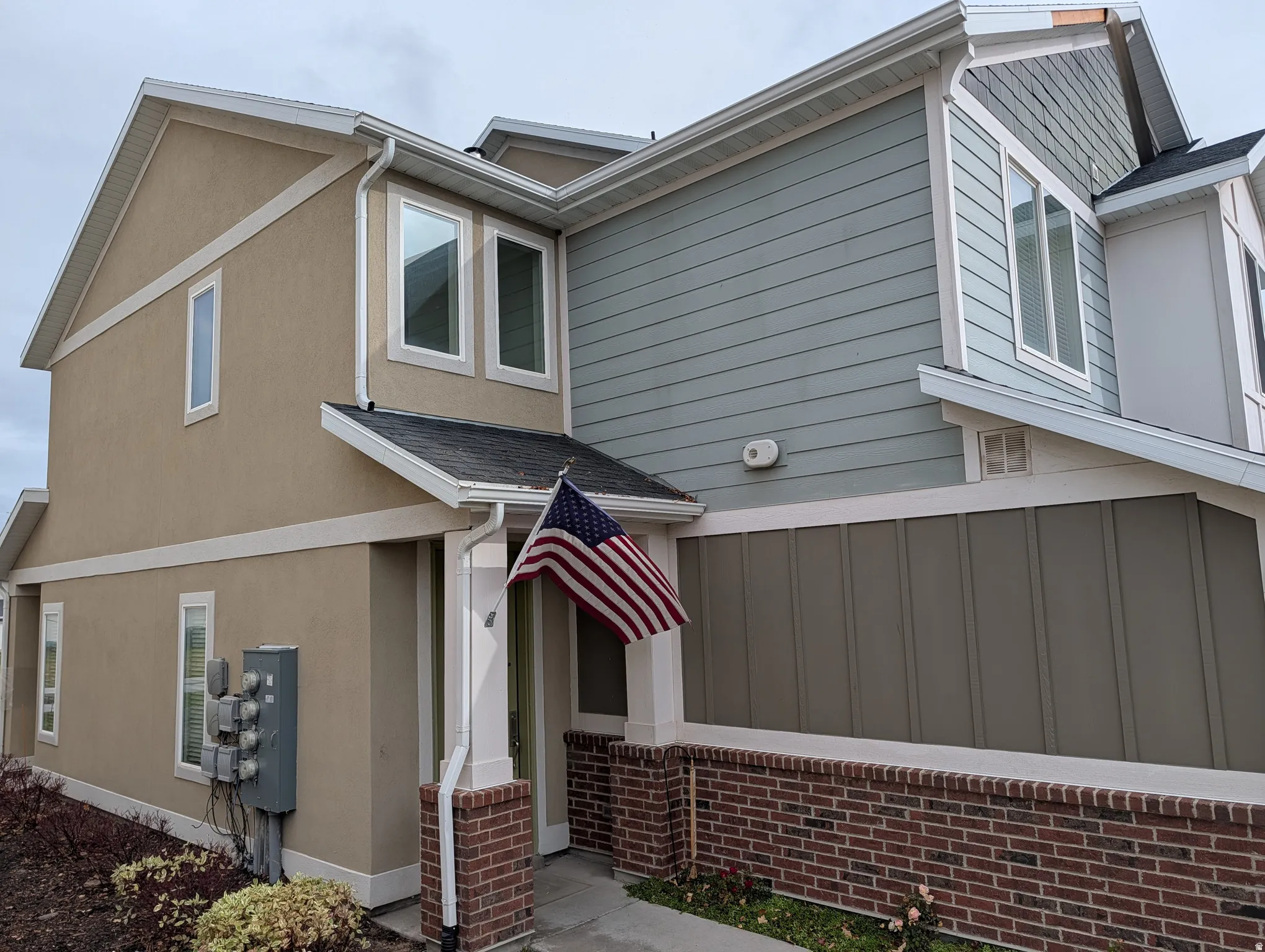 View of property exterior with stucco siding and brick siding