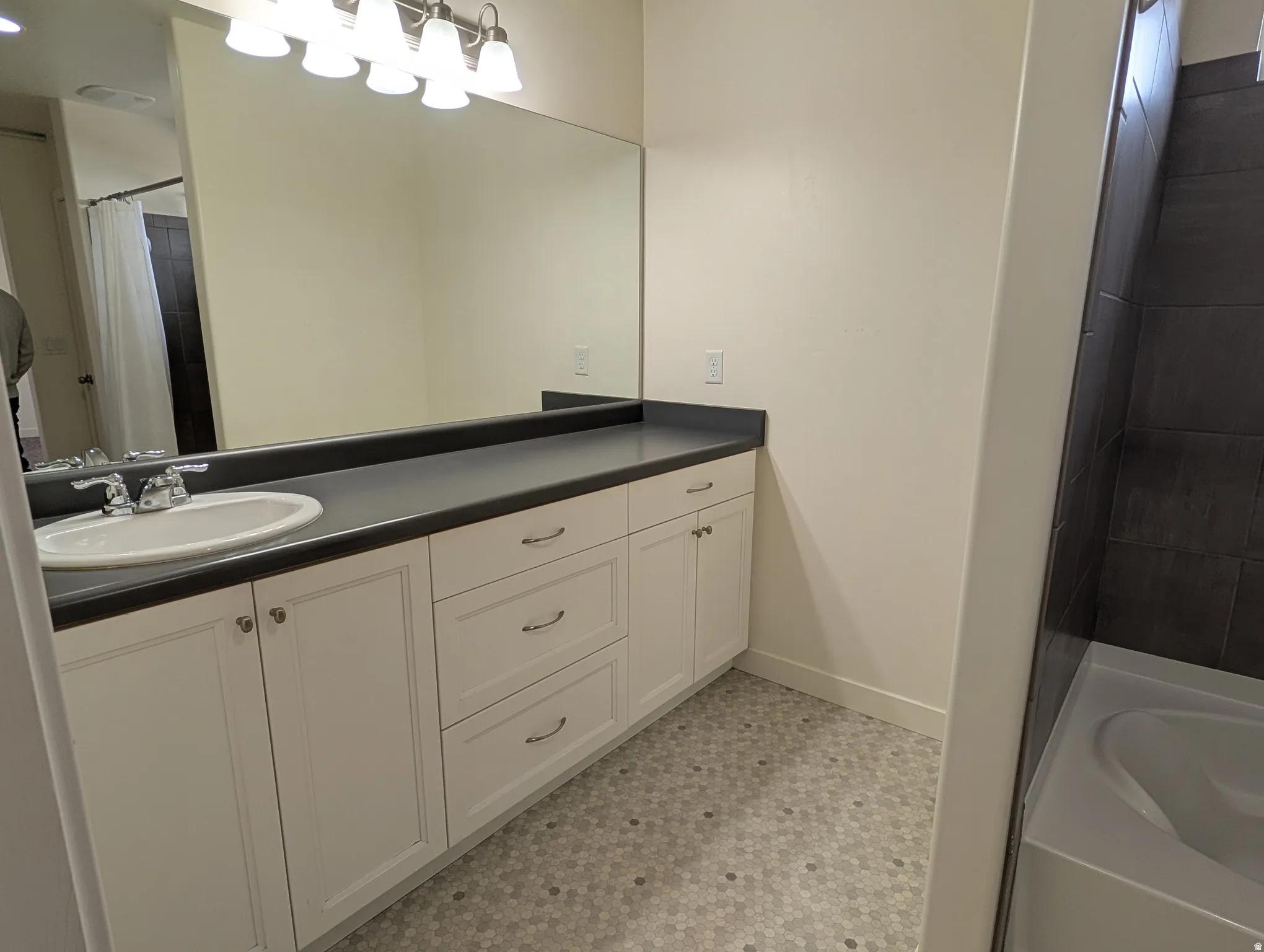 Bathroom with curtained shower, vanity, a tub to relax in, and light floors