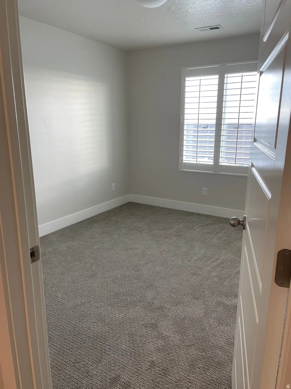 Spare room with carpet floors and a textured ceiling