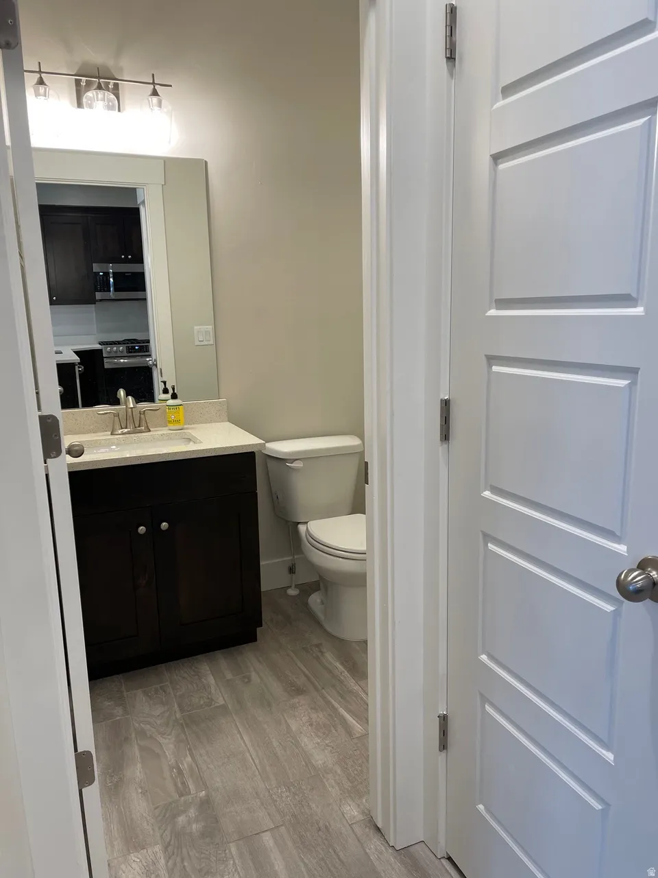 Half bathroom with vanity and light wood-style flooring