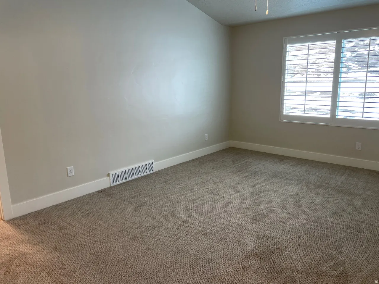 Carpeted empty room featuring baseboards