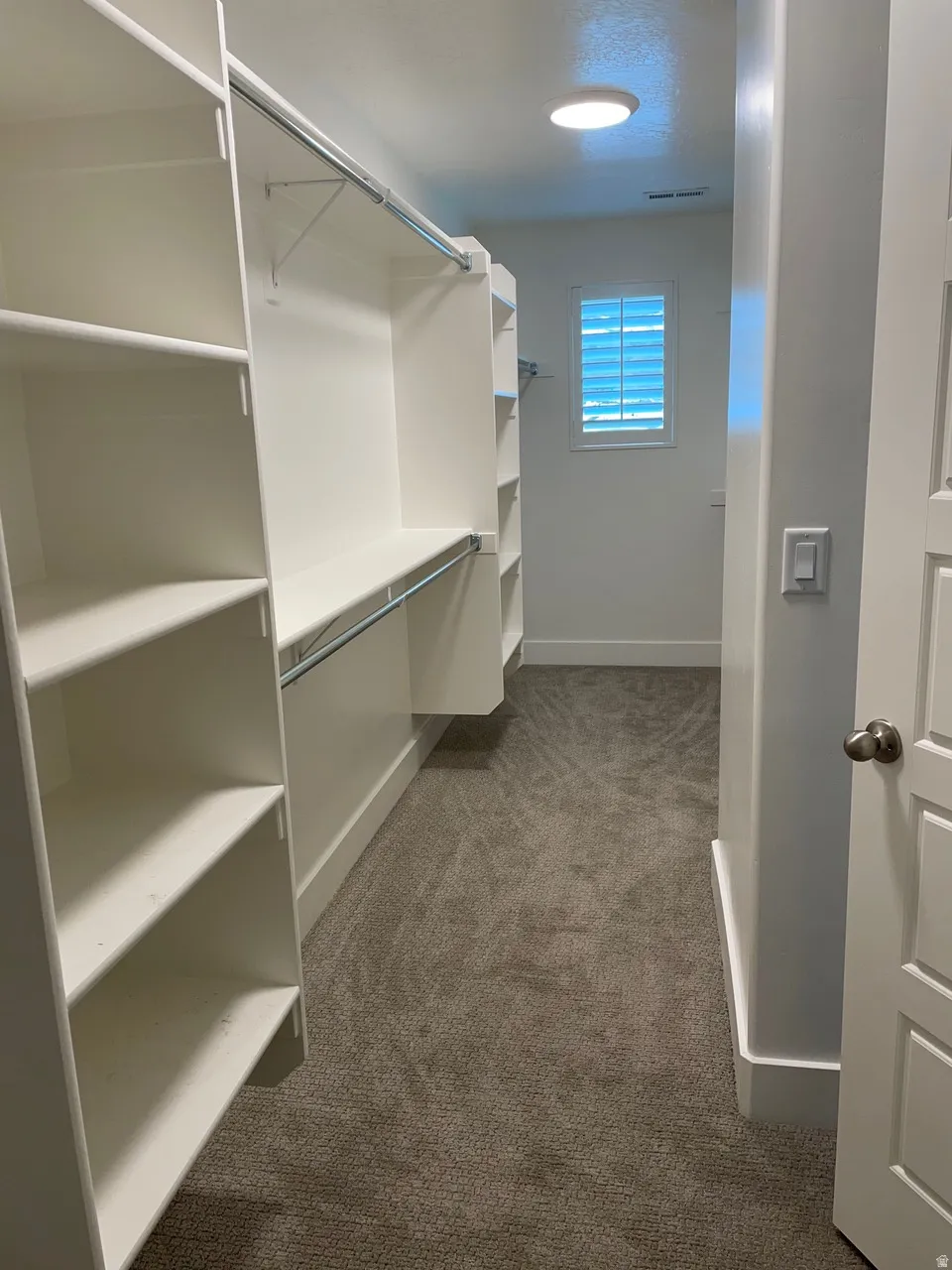 Walk in closet featuring light carpet