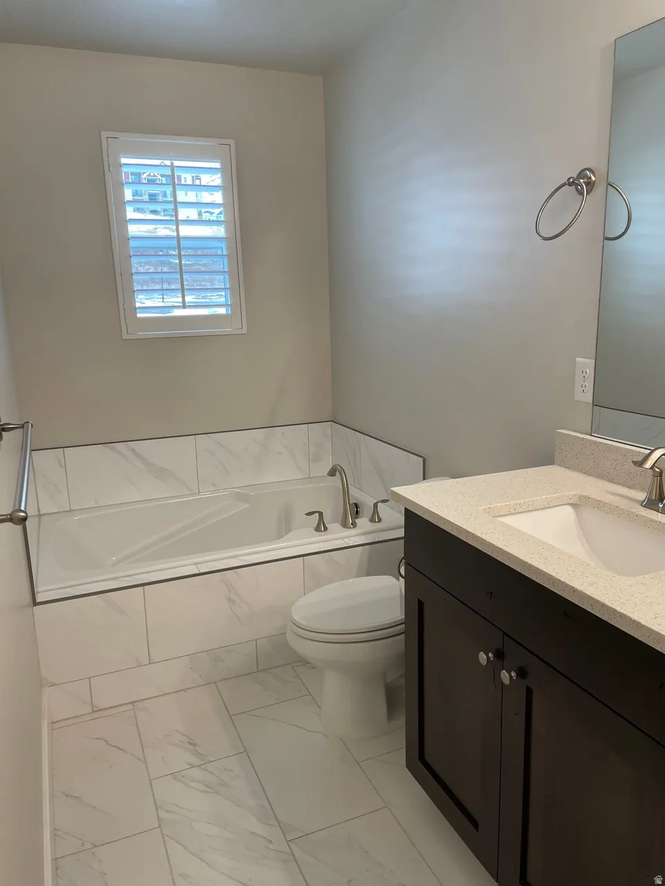 Bathroom with a bath, vanity, and light marble finish floors