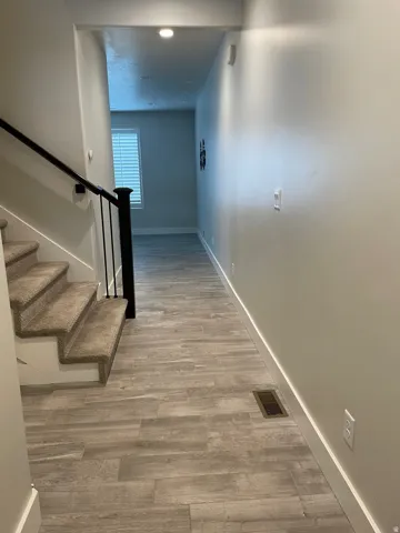 Corridor featuring baseboards and light wood-style floors