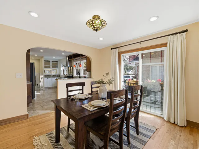 Dining room featuring arched walkways, light wood finished floors, and recessed lighting