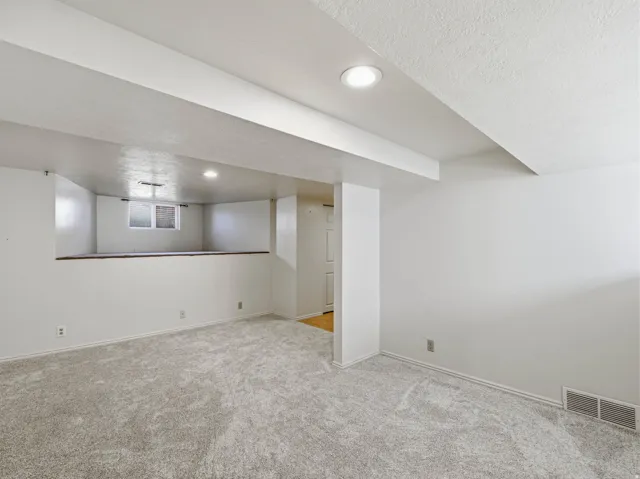 Basement with carpet, a textured ceiling, and recessed lighting