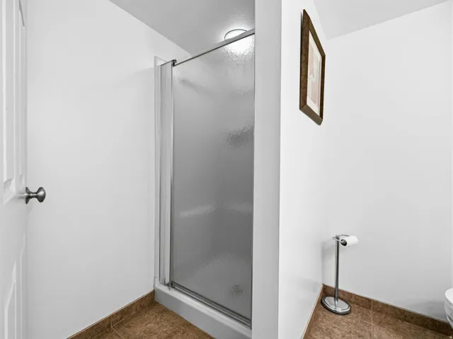 Bathroom featuring a stall shower and dark tile patterned floors