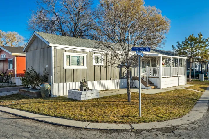 Manufactured / mobile home featuring a front lawn and a shingled roof