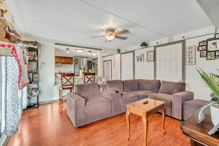 Living area with light wood-style floors and a ceiling fan
