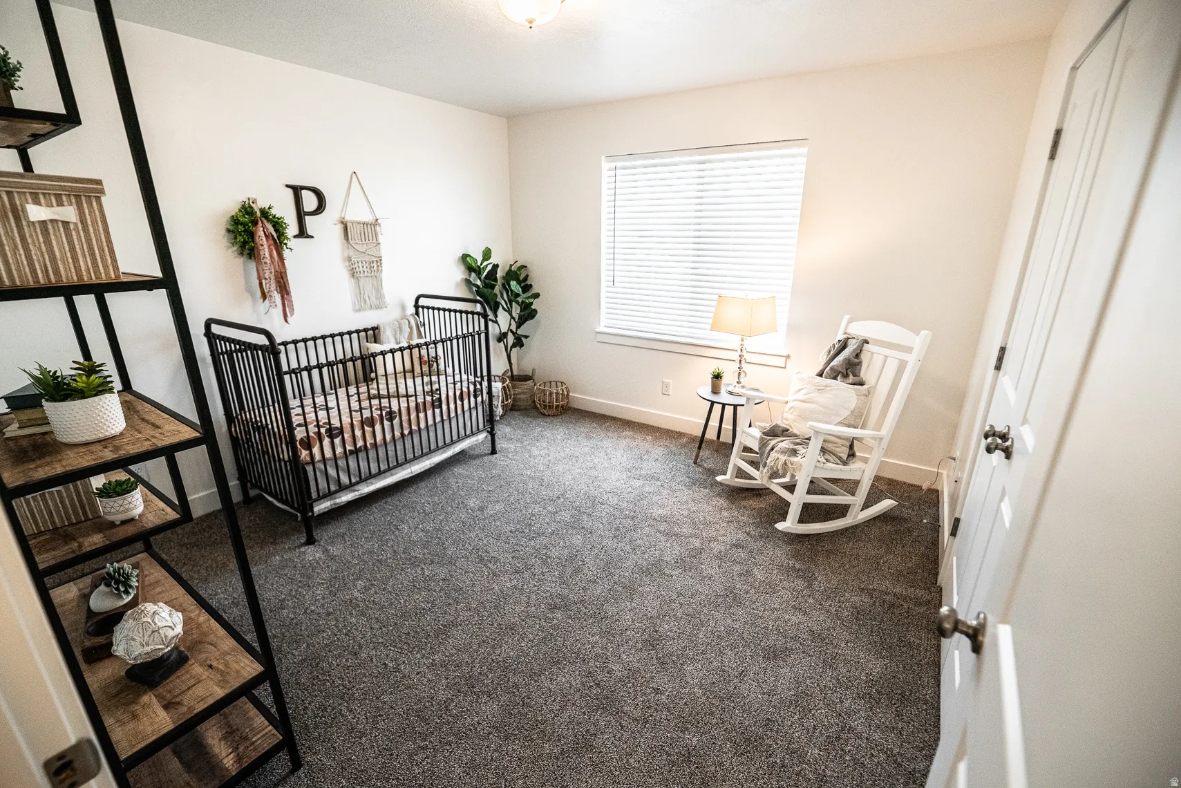Bedroom featuring carpet flooring and a crib