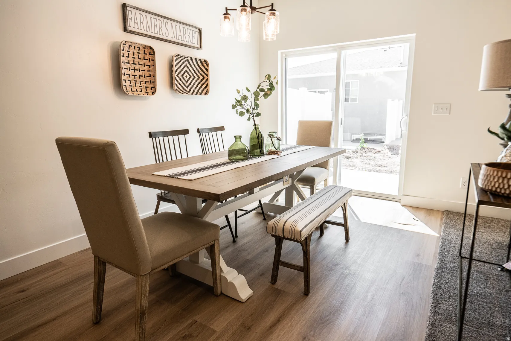 Dining space with hanging lights and dark wood finished floors
