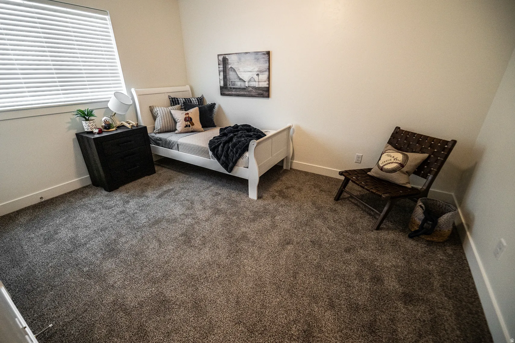 Bedroom with dark carpet and baseboards