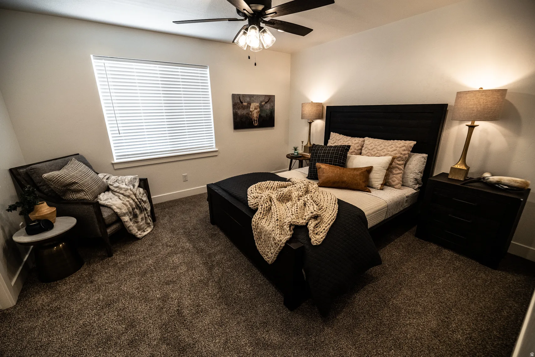 Bedroom with dark carpet and a ceiling fan