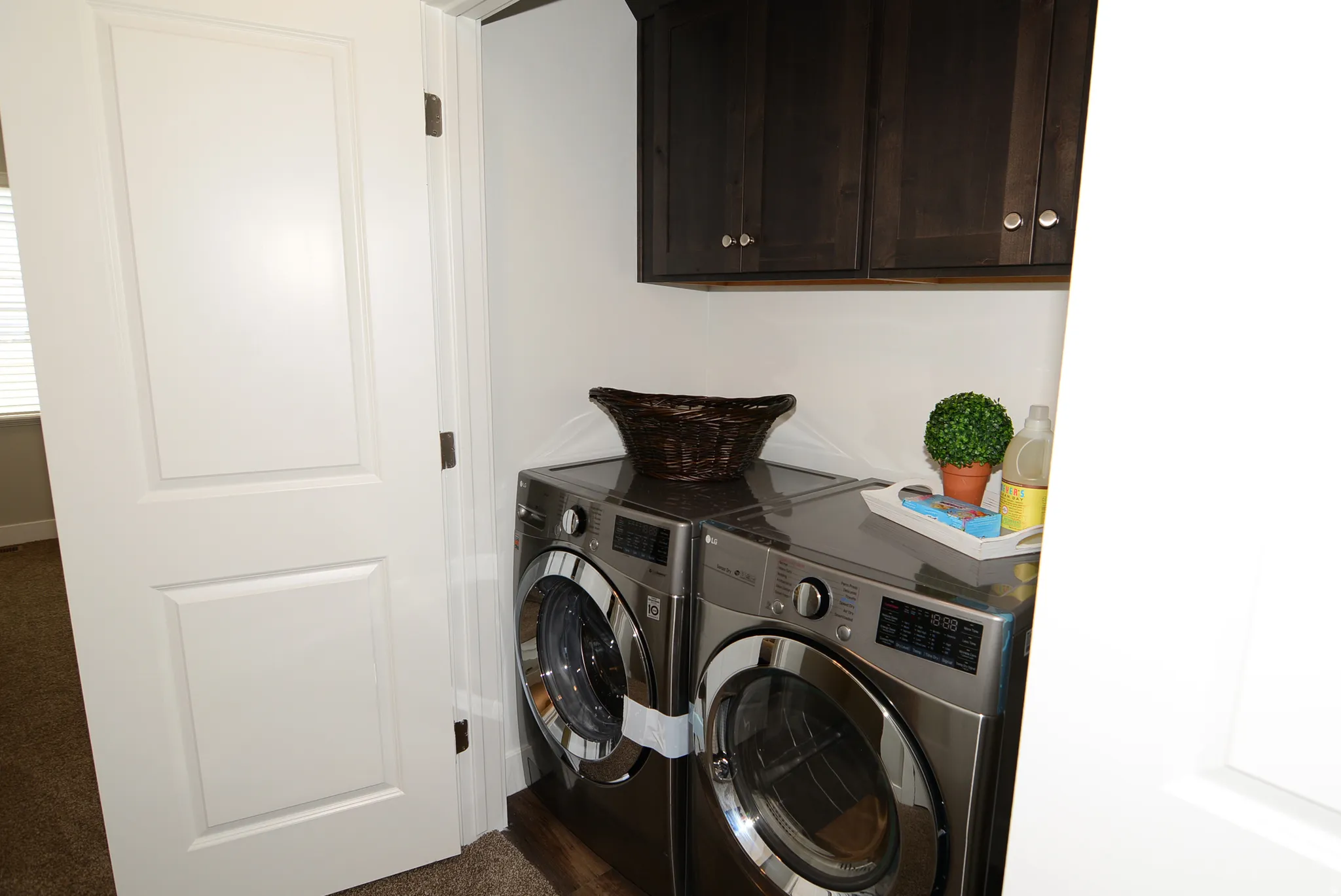 Laundry area featuring separate washer and dryer and cabinet space