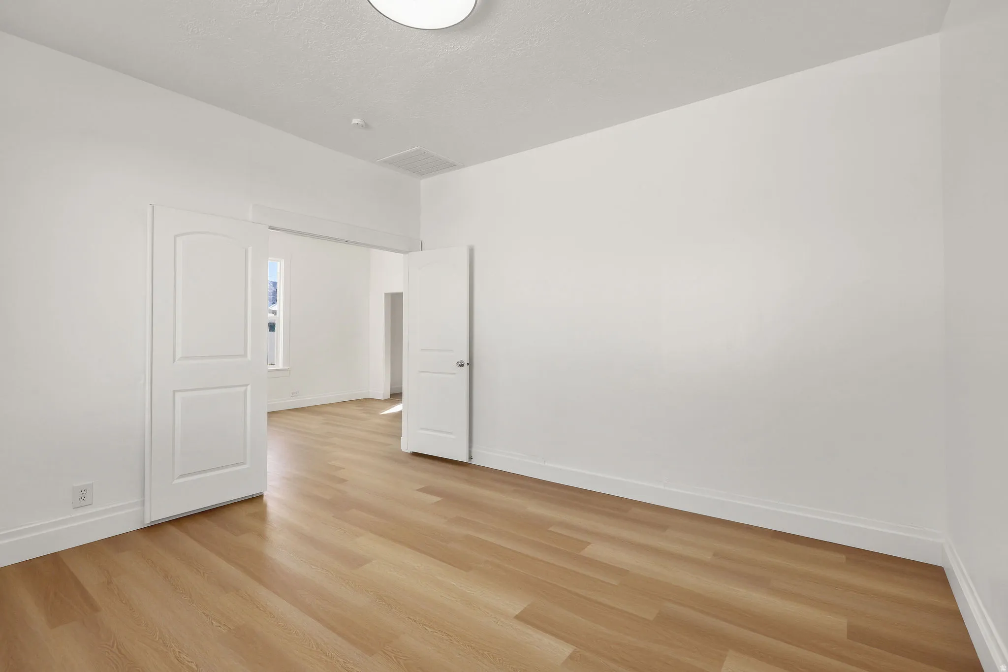 Spare room with baseboards and light wood finished floors