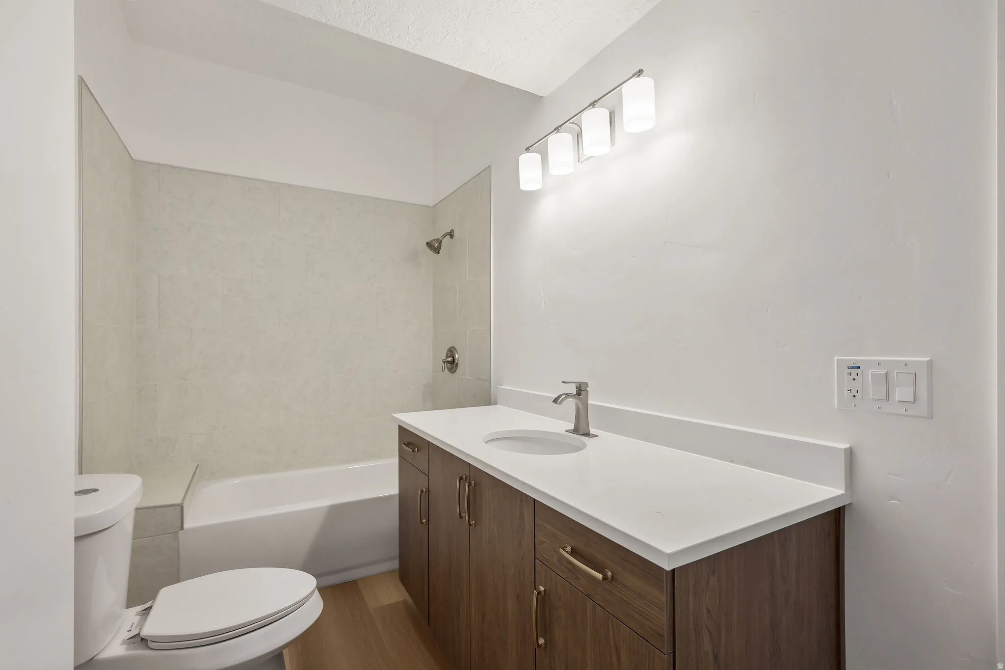 Bathroom with vanity, bathing tub / shower combination, and light wood-style floors