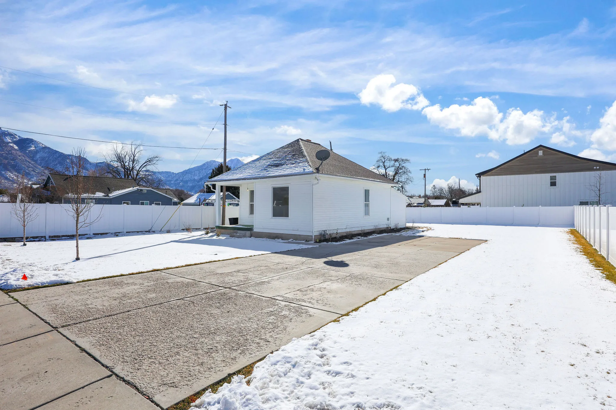 Snow covered rear of property with a mountain view