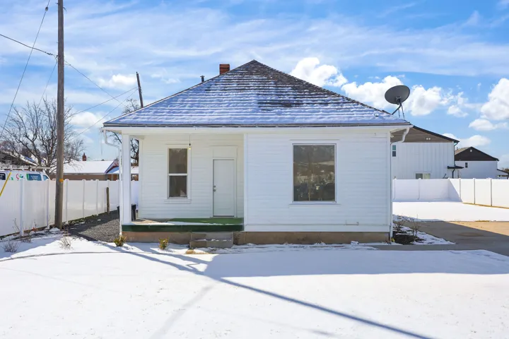 View of front of house featuring a chimney and covered porch