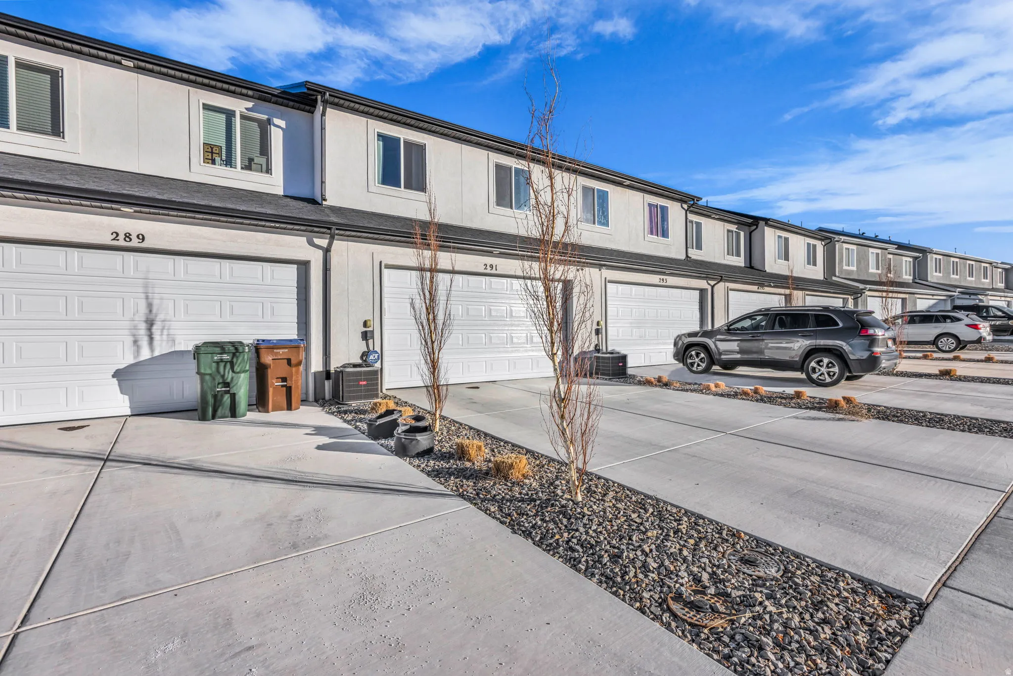 Exterior space with driveway, a garage, and a residential view