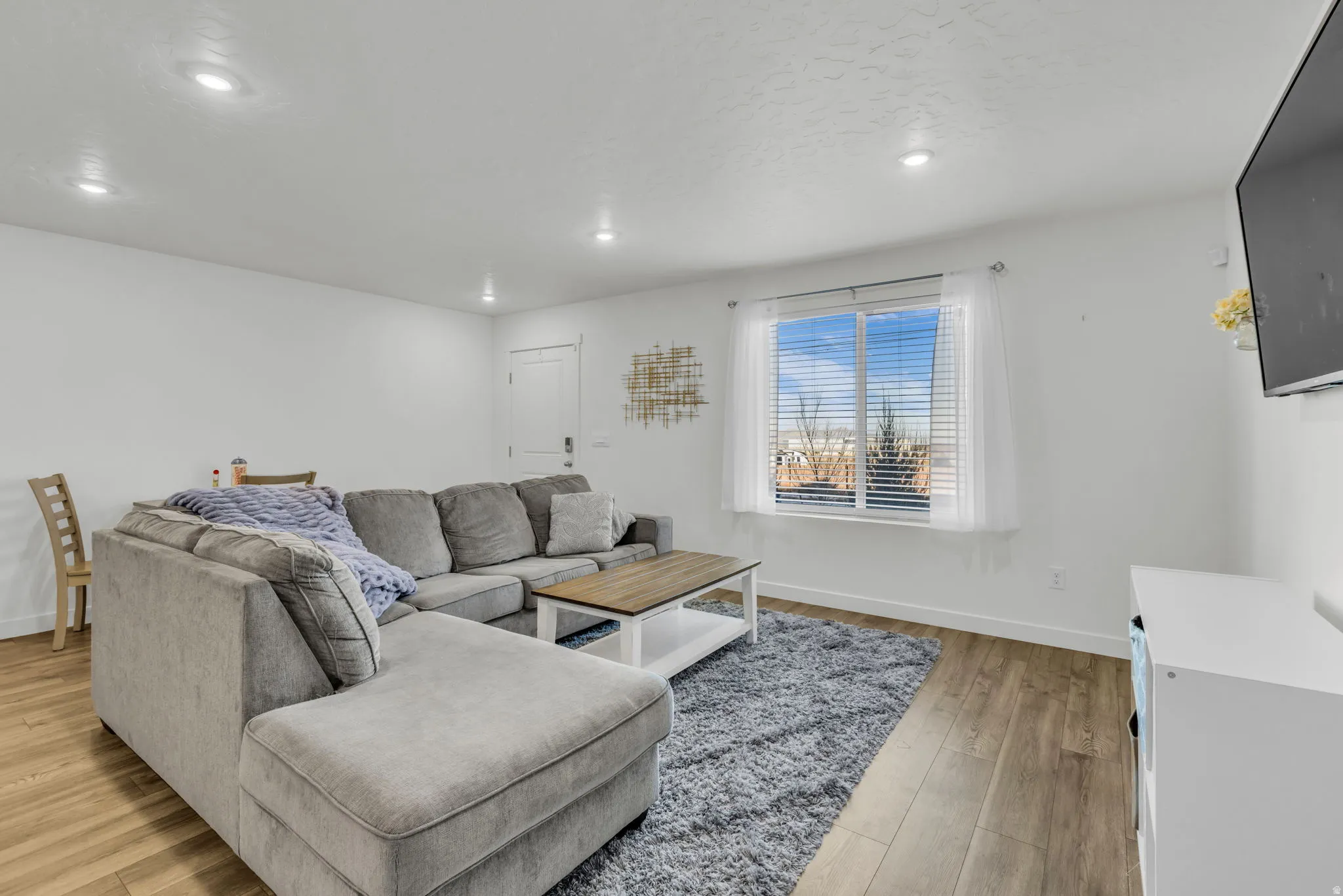 Living area featuring light wood-type flooring and recessed lighting