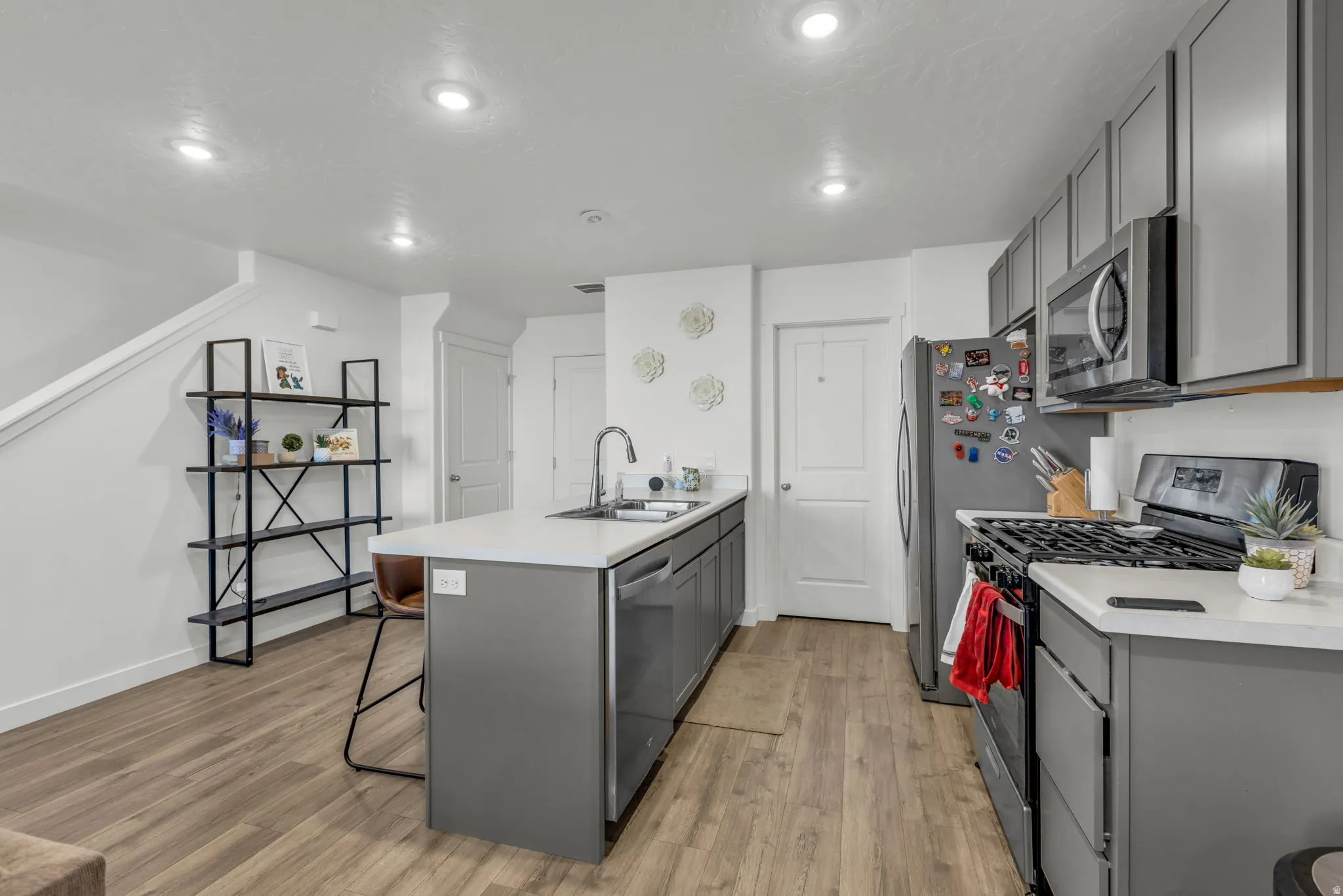 Kitchen featuring gray cabinetry, a peninsula, stainless steel appliances, and recessed lighting