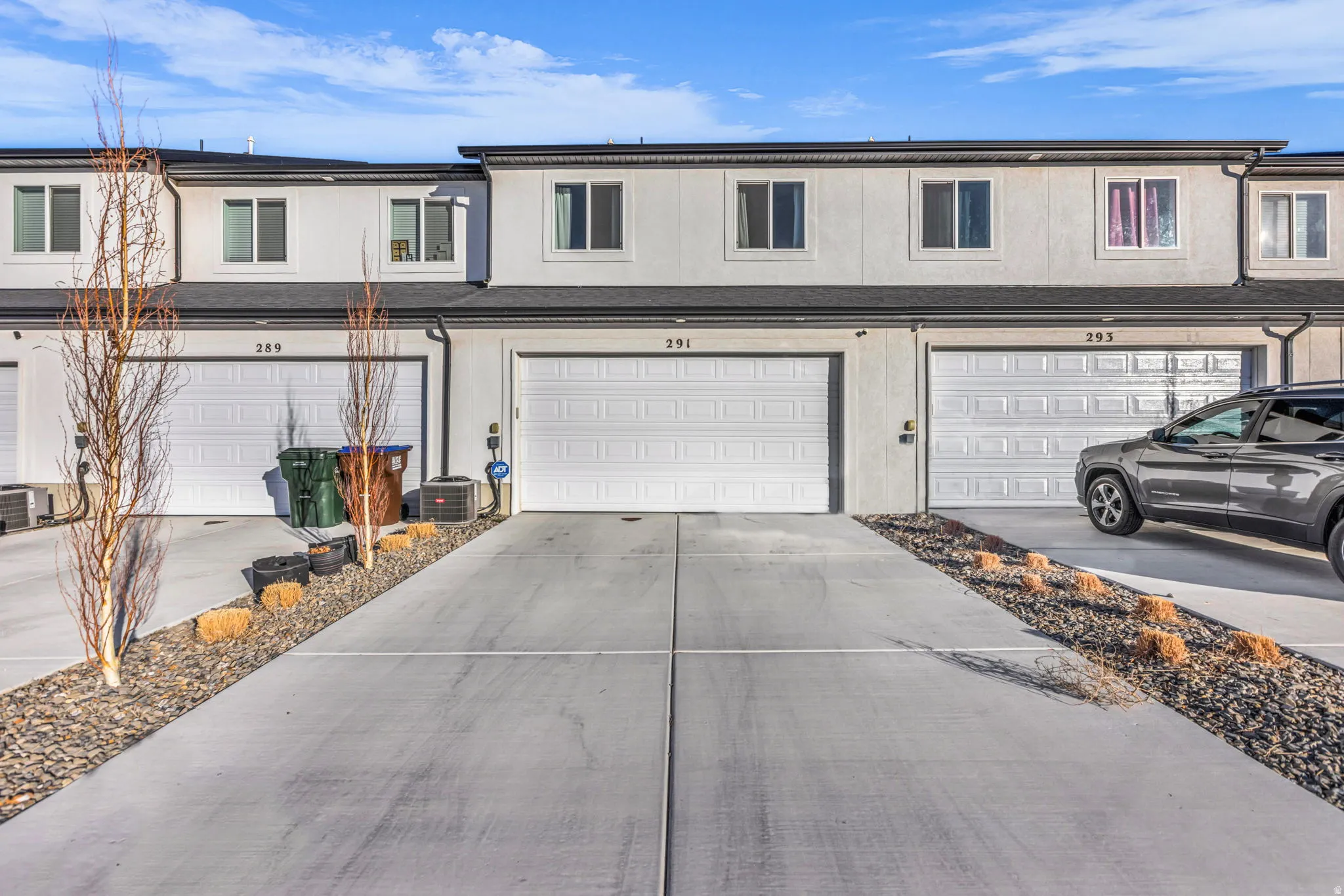 Traditional home with stucco siding, a garage, and concrete driveway