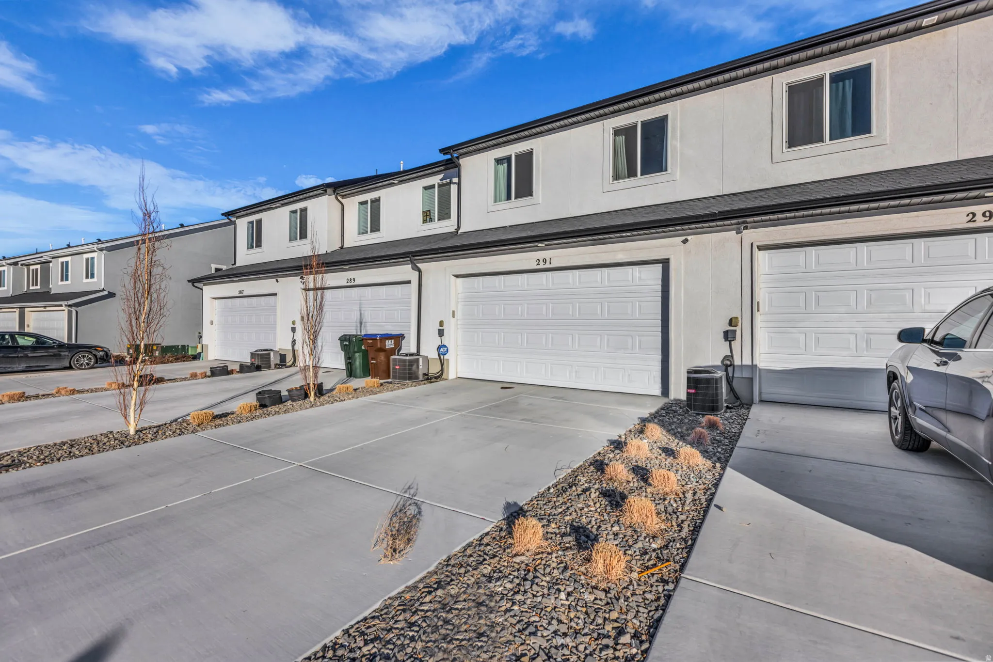 View of front of property with an attached garage, concrete driveway, and stucco siding
