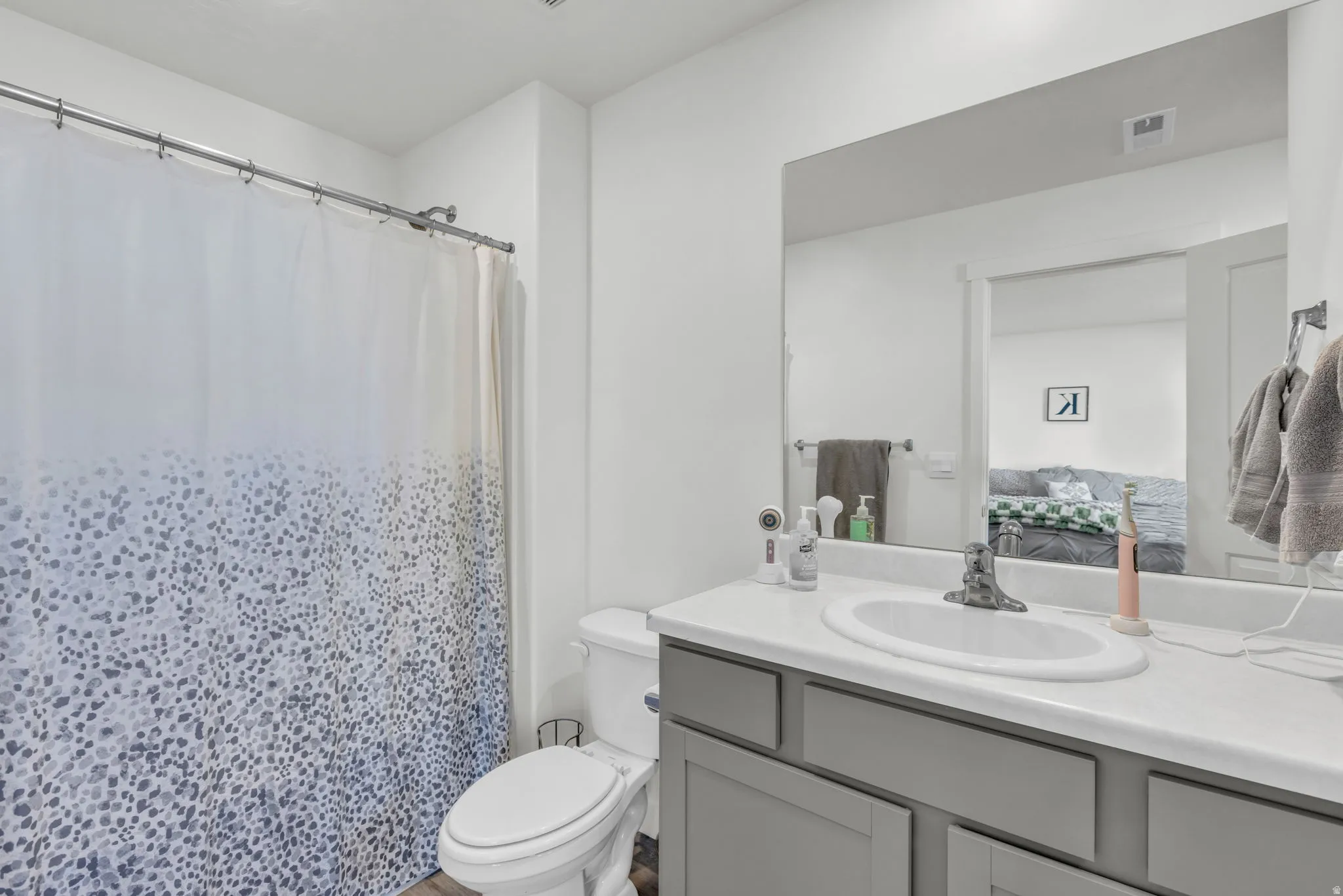 Bathroom with a shower with curtain and vanity