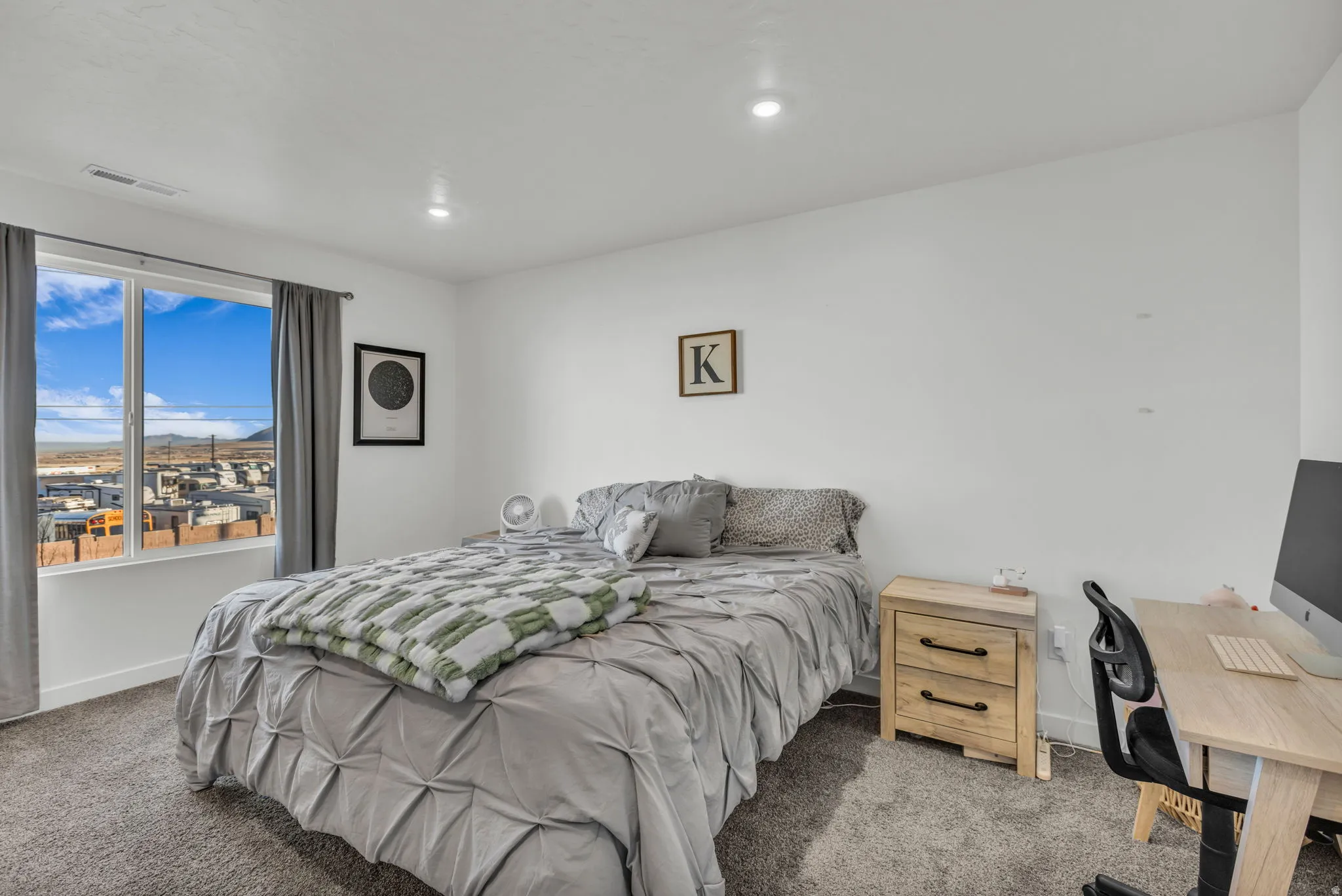 Carpeted bedroom with an office area and recessed lighting