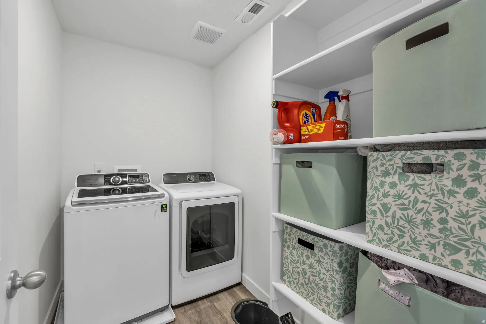 Laundry area featuring wood finished floors and washer and clothes dryer