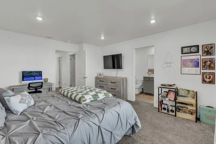 Bedroom with carpet, ensuite bathroom, and recessed lighting