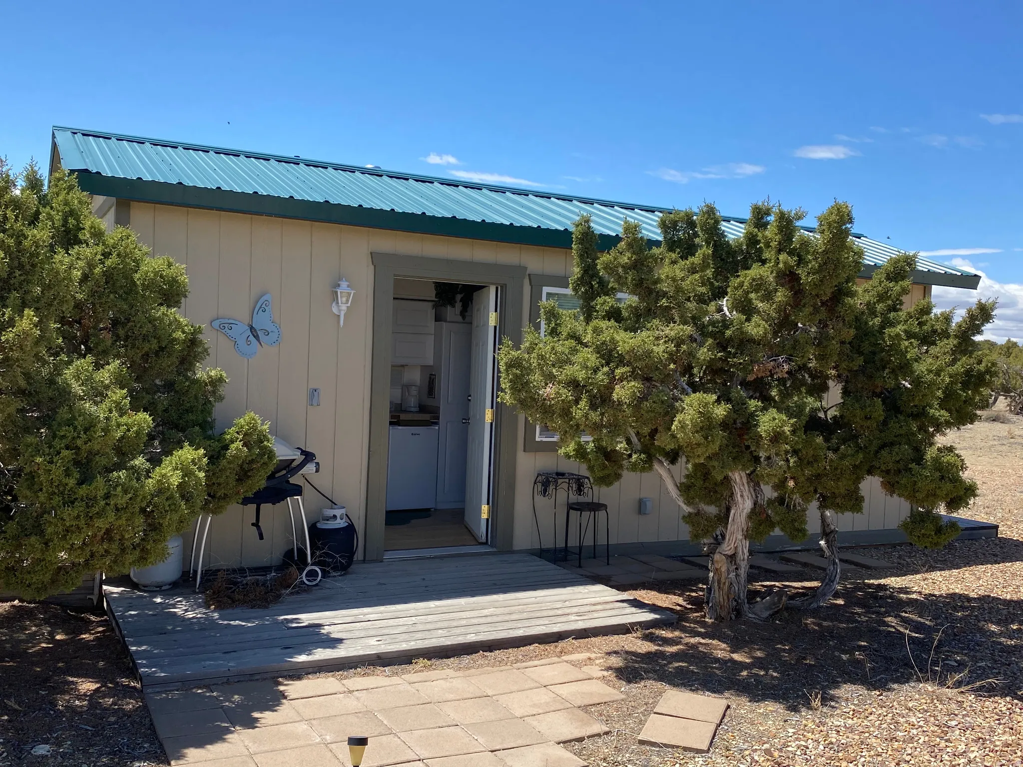 View of exterior entry featuring a metal roof and a patio area