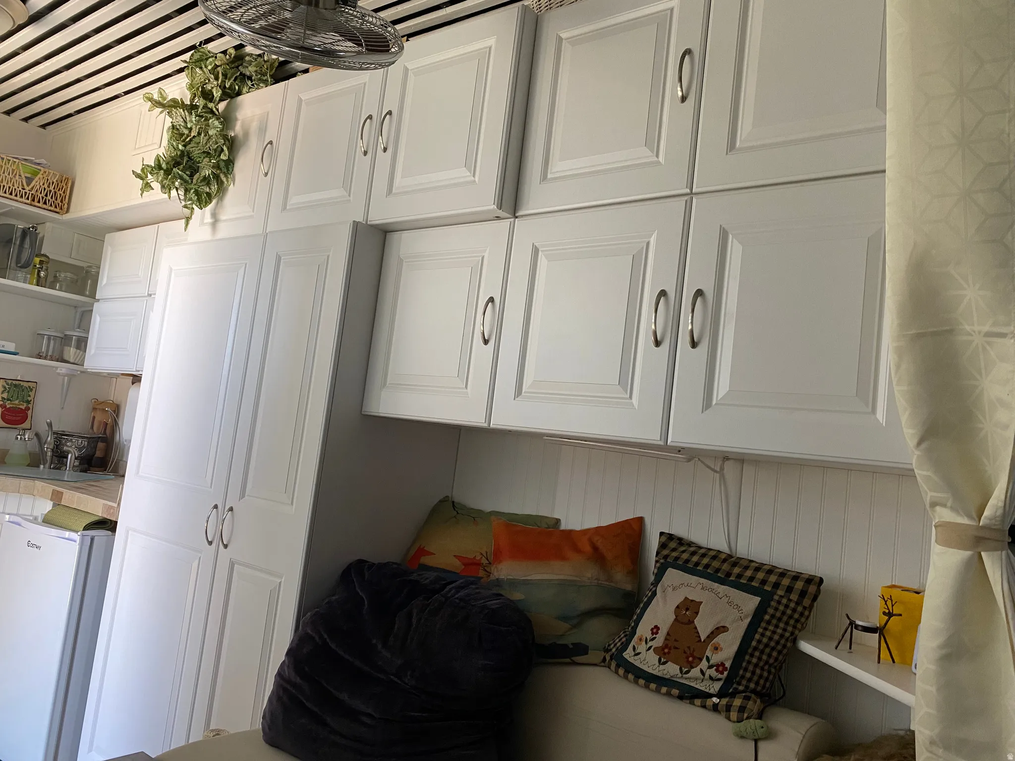 Interior space with white refrigerator and a decorative wall