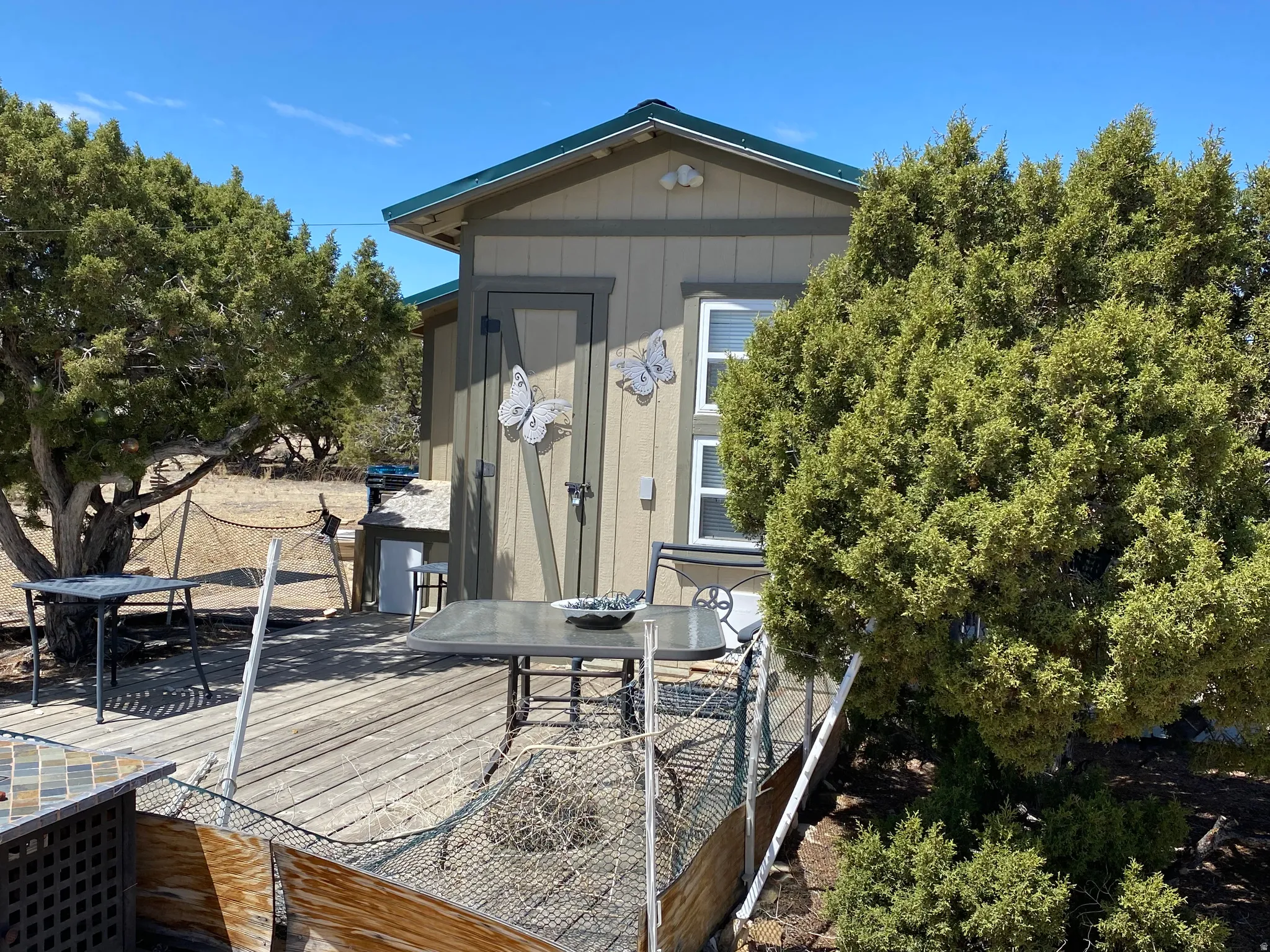 Wooden deck featuring outdoor dining area and a storage unit
