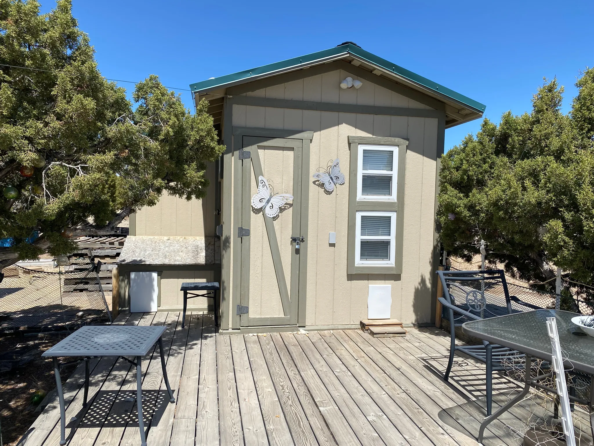 Wooden terrace with a storage shed and outdoor dining space