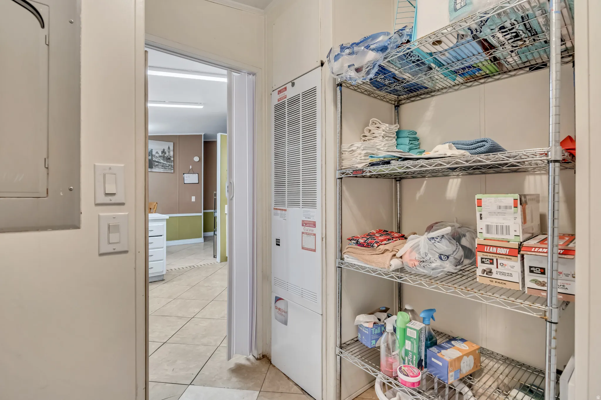 Storage area featuring electric panel and a heating unit