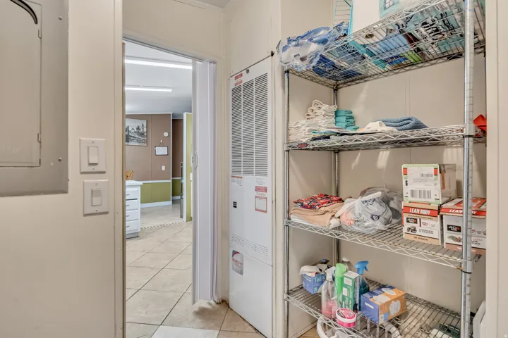 Storage area featuring electric panel and a heating unit