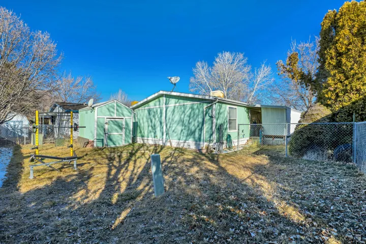 Rear view of house featuring a shed and a gate