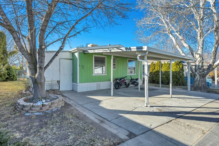 View of front facade featuring an attached carport, driveway, and covered porch