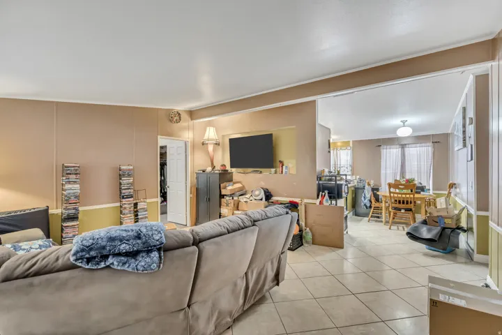 Living room with light tile patterned floors and a decorative wall
