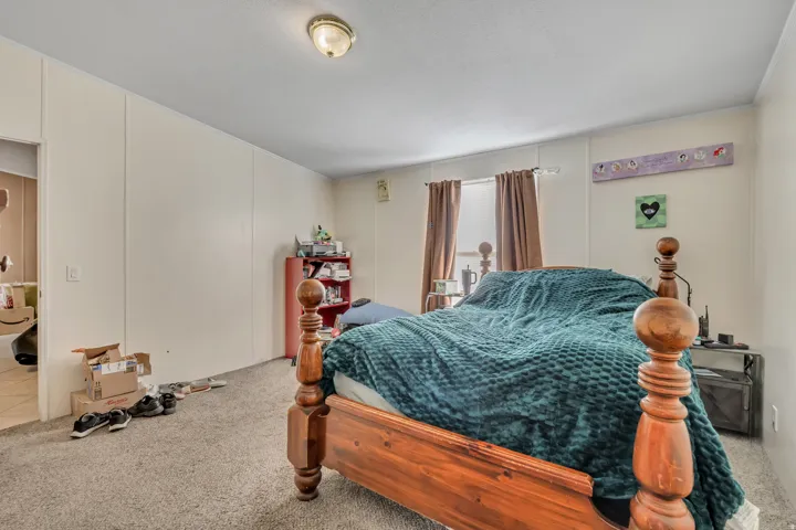 Bedroom with carpet and a decorative wall