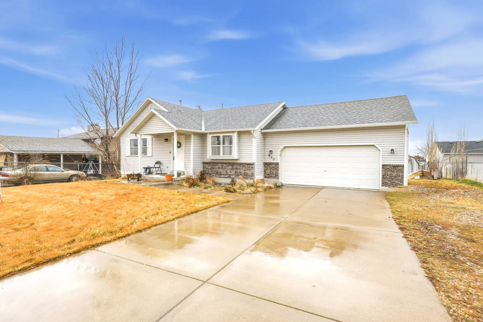 View of front facade with driveway, a garage, a shingled roof, and a front lawn