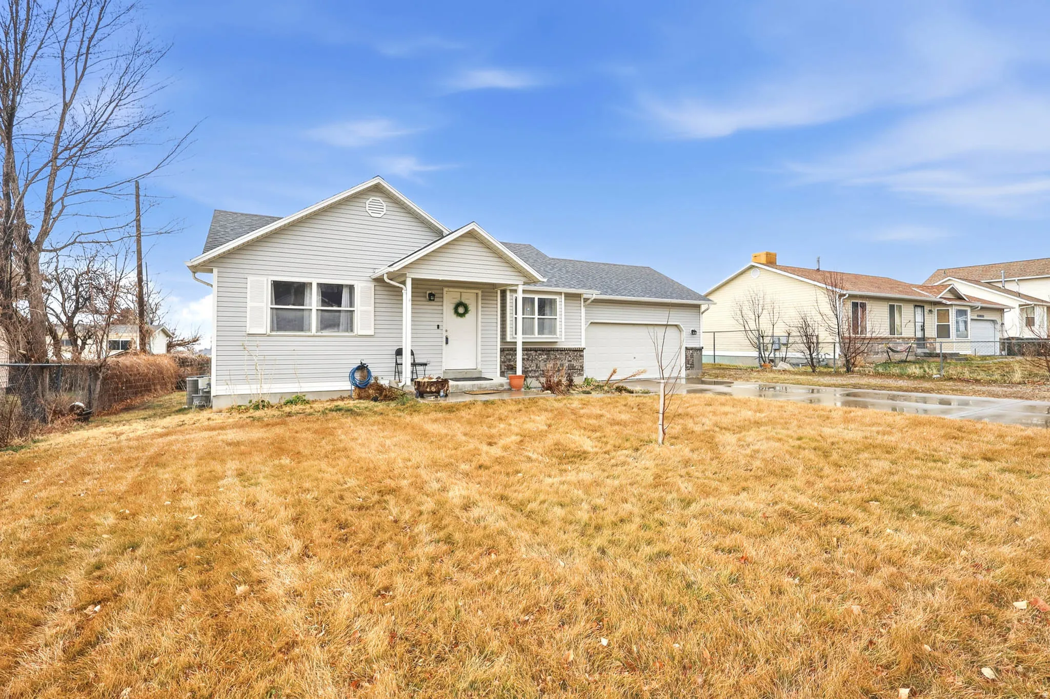 View of front of home with a garage, roof with shingles, and driveway