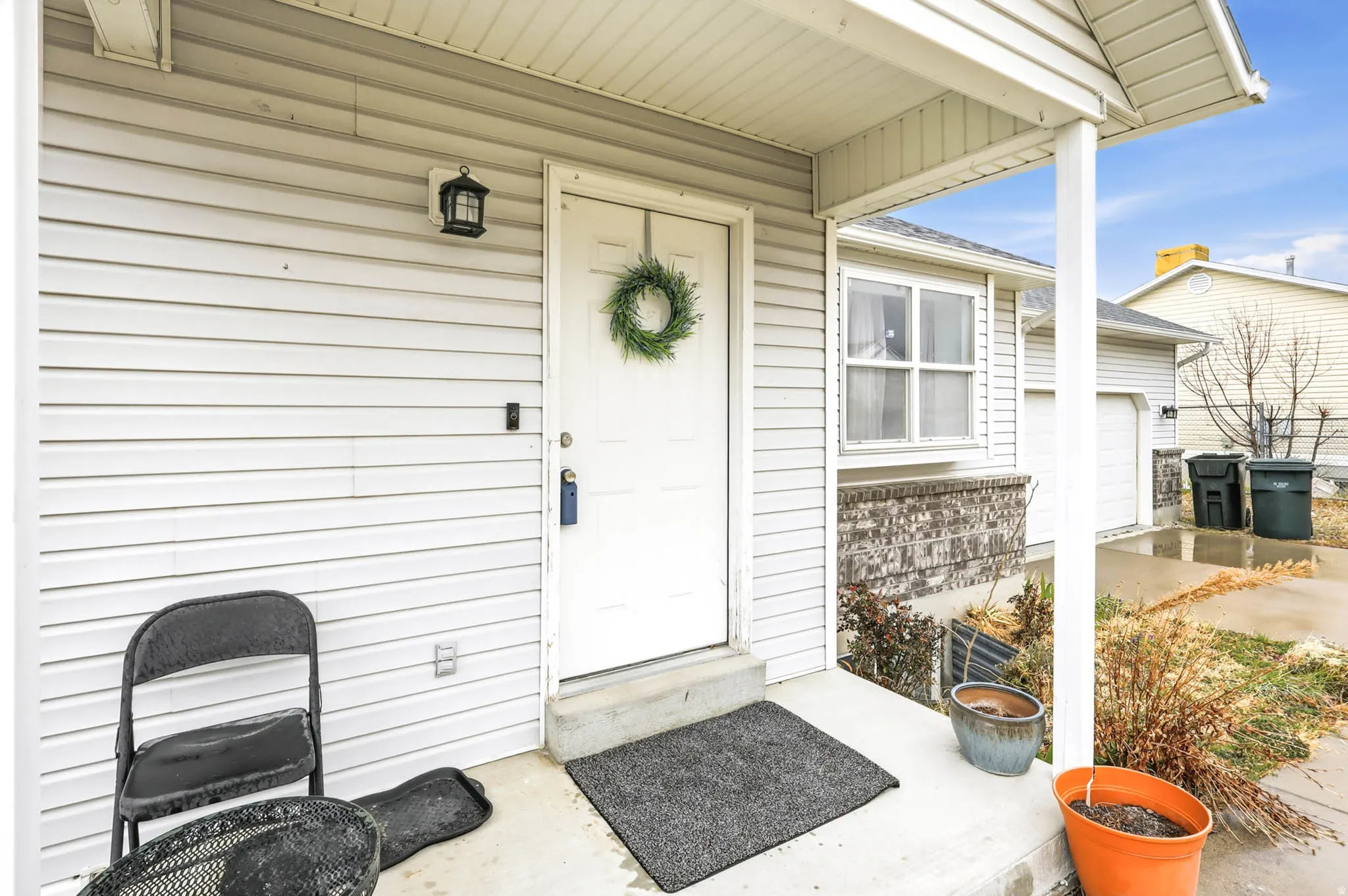 Doorway to property featuring a garage, roof with shingles, and covered porch