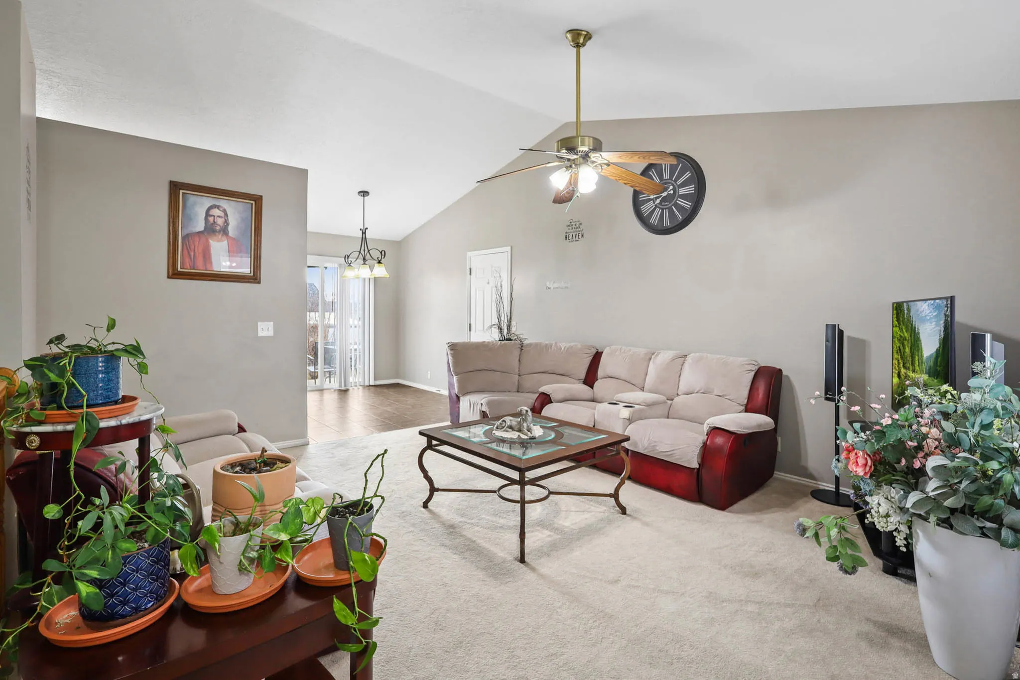 Living area with ceiling fan, carpet floors, and hanging lights