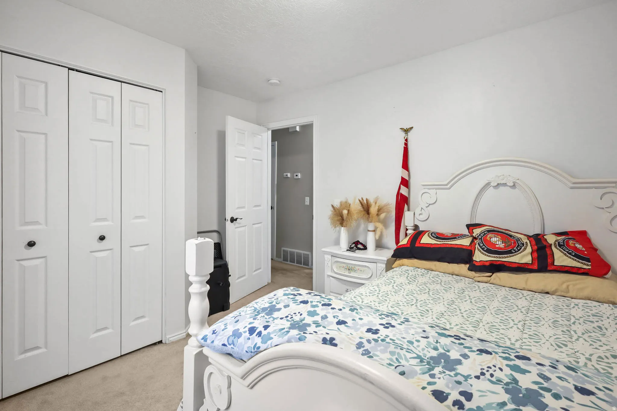 Bedroom featuring light colored carpet and a closet